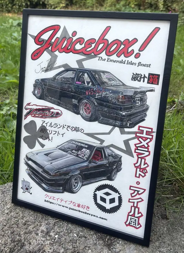Jessie&rsquo;s Juicebox poster drawing in a black frame, standing on a rock in front of green hedges